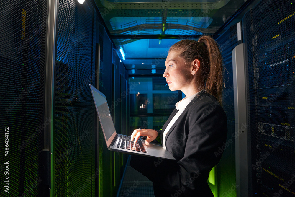 Fototapeta premium Adult woman network engineer in server room