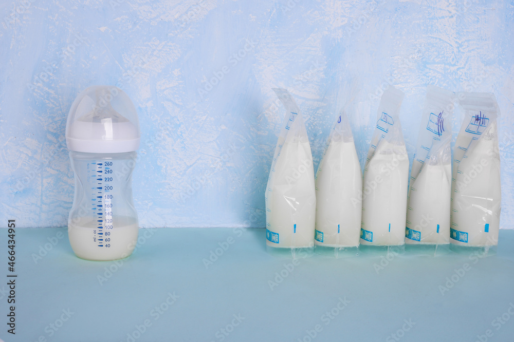 Bags with breast milk on blue background. Befrosting milk. Milk bottle