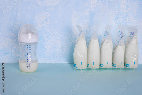 Bags with breast milk on blue background. Befrosting milk. Milk bottle. Working mom. Milk bank. Expressing breast milk. Breast-feeding. Freezing and storing milk. Donated milk.Copyspace
