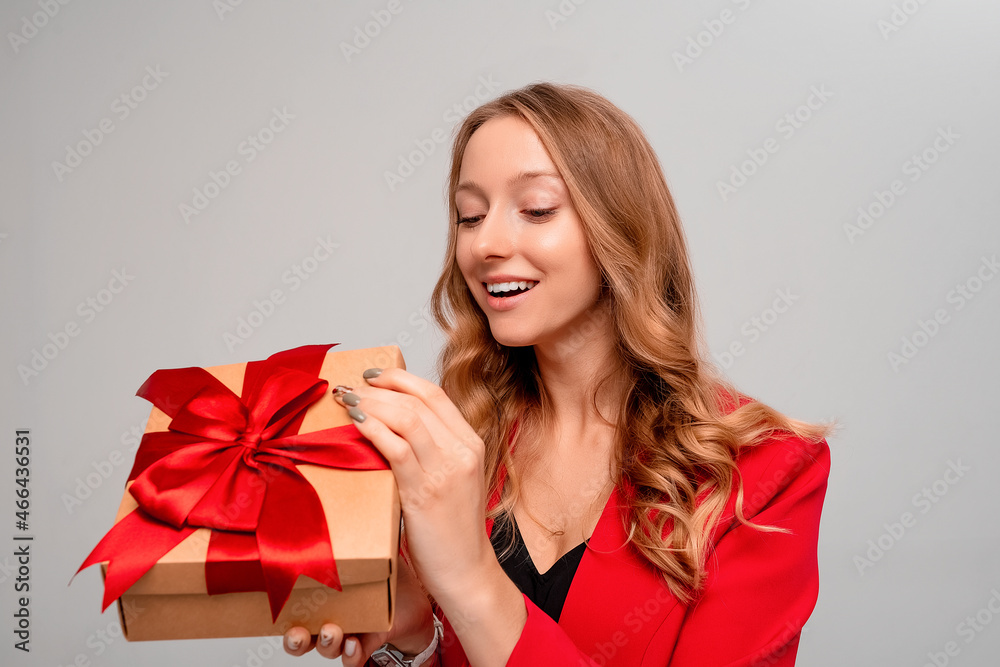 Curious young woman holding in hands unboxed present. Female person enjoying long-awaited birthday present, dreams come true. Studio shot gray background Curious young woman holding in hands unboxed present. Female person enjoying long-awaited birthday present, dreams come true. Studio shot gray background