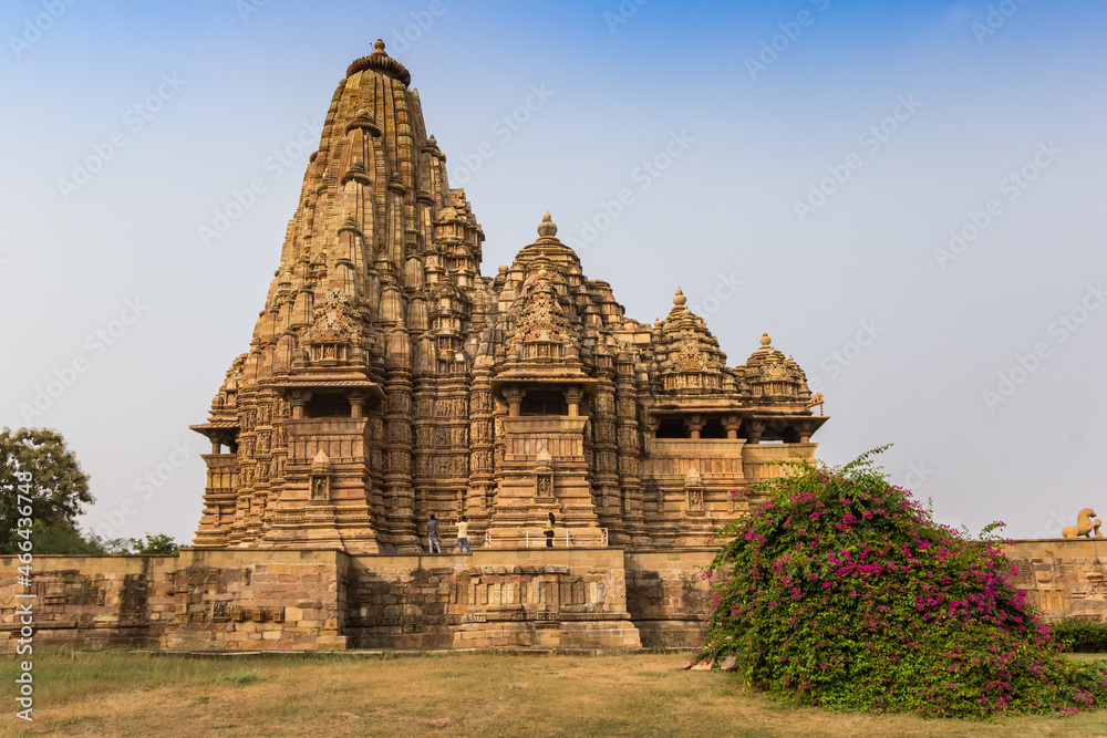 Temple and pink flowers in historic city Khajuraho, India Temple and pink flowers in historic city Khajuraho, India