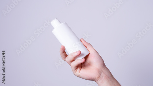 a man holding a bottle of lotion in his hand