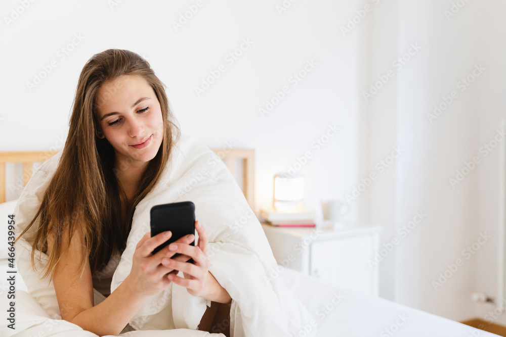 Smiling young woman with brown hair using smart n bed Smiling young woman with brown hair using smart n bed