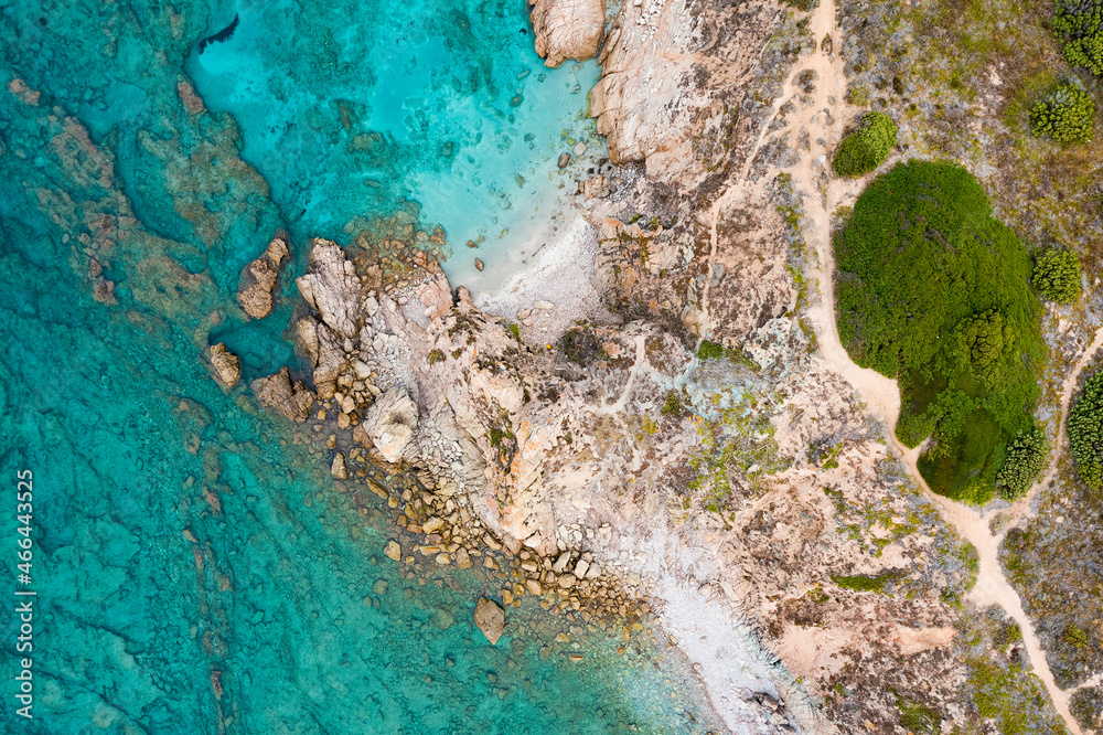 View from above, stunning aerial view of a rocky coastline bathed by a turquoise water. Rena Majore, Sardinia, Italy.
