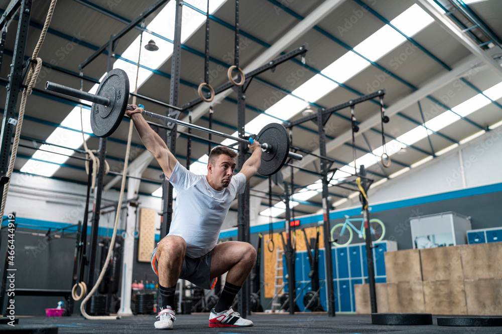 Male athlete doing squats in gym Male athlete doing squats in gym
