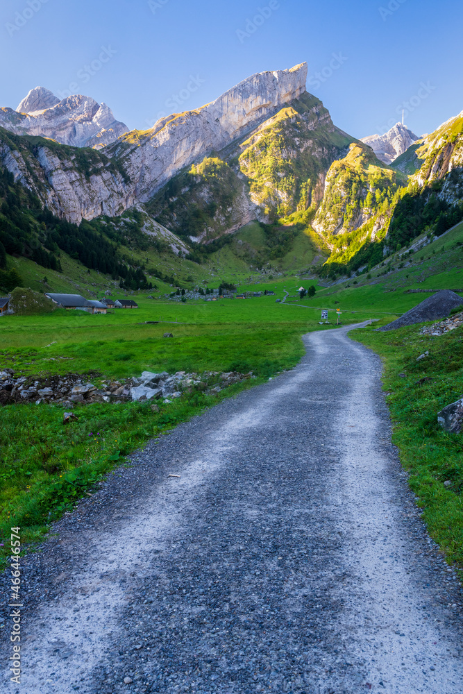 Empty dirt road stretching through valley in Alpstein range at dawn Empty dirt road stretching through valley in Alpstein range at dawn