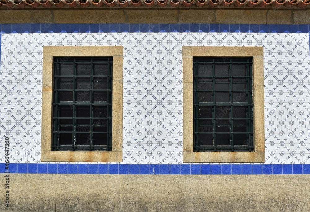 
Two windows and a wall with azulejos, traditional blue-white wall tiles in Portugal