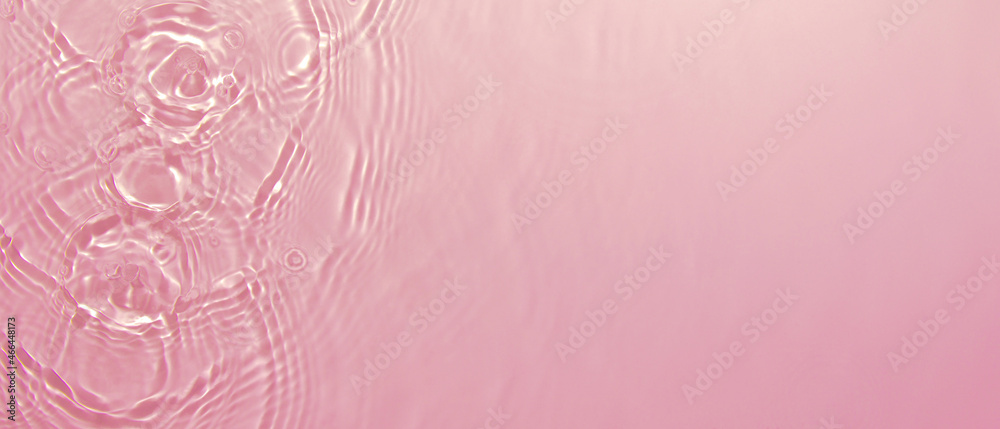 Transparent pink clear water surface texture with ripples, splashes and bubbles. Abstract summer banner background Water waves in sunlight with copy space Cosmetic moisturizer micellar toner emulsion