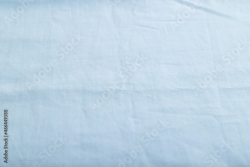 Fragment of smooth cotton blue tissue. Side view, natural textile background.