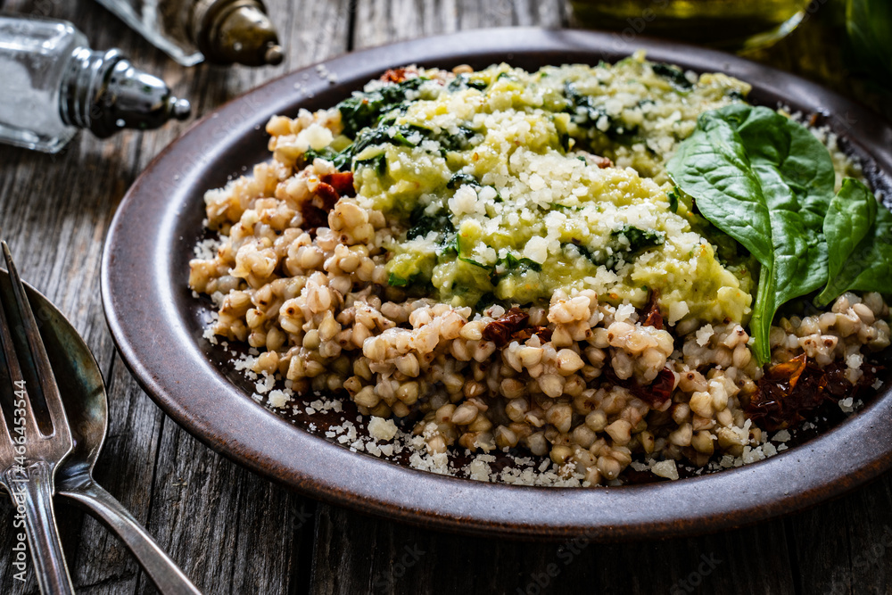 Boiled white buckwheat groats, sun dried tomatoes, parmesan and spinach served on wooden table
Boiled white buckwheat groats, sun dried tomatoes, parmesan and spinach served on wooden table