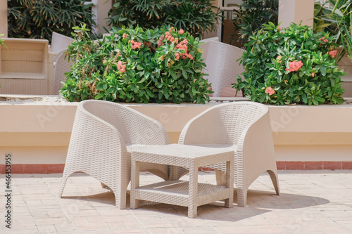 Plastic wicker garden furniture set. A table and two armchairs made of wicker plastic. Lightweight portable garden furniture for a country house, terraces.