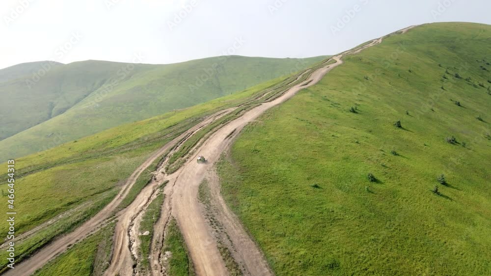 aerial view suv vehicle going up by hill to the top of mountain aerial view suv vehicle going up by hill to the top of mountain