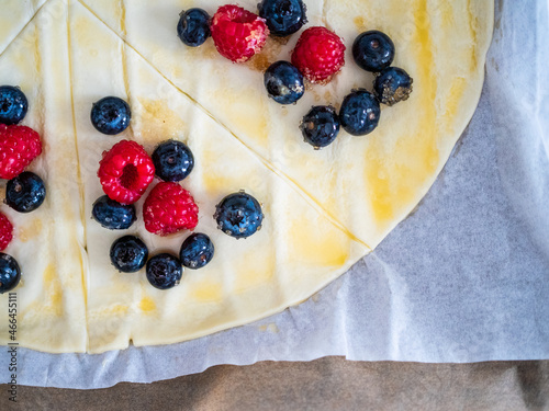 Puff pastry with raspberries and blueberries on baking paper