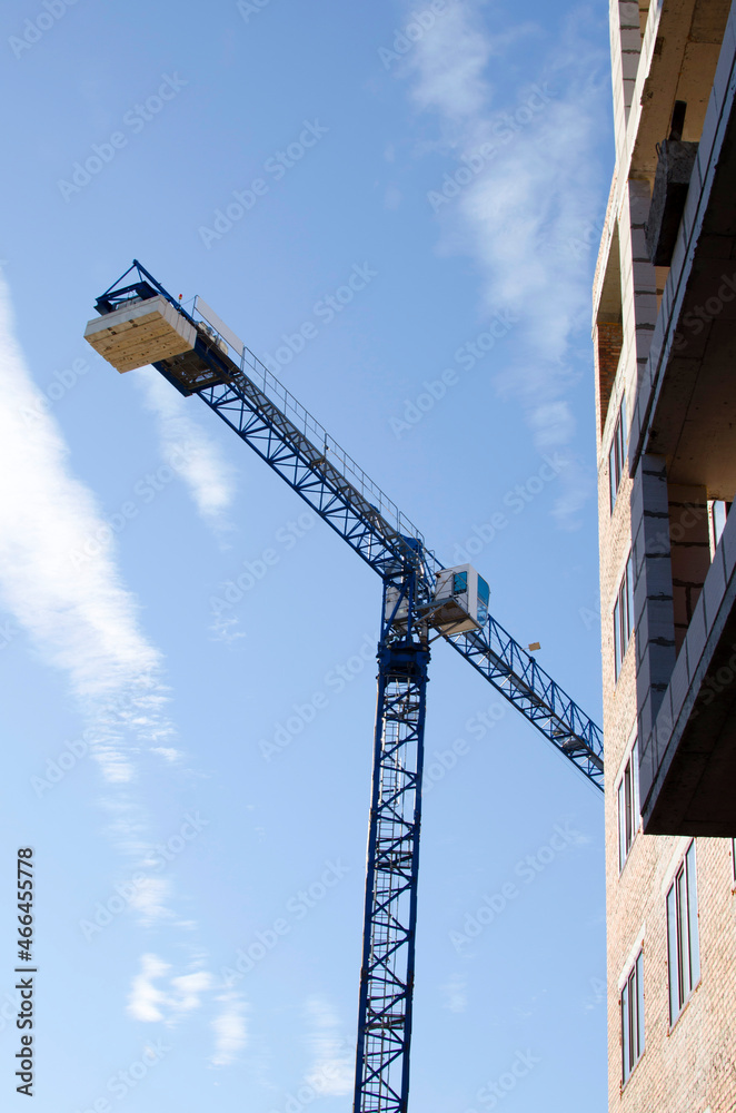 Crane and part of building against blue sky background. Construction site Crane and part of building against blue sky background. Construction site