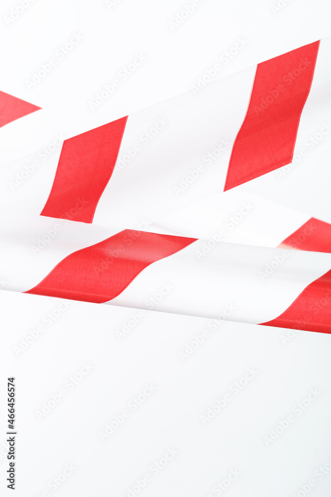 Obraz premium Red and white striped fencing tape on a white background.