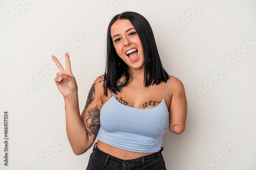 Young caucasian woman with one arm isolated on white background joyful and carefree showing a peace symbol with fingers.