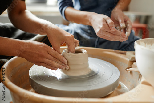 Photo Close up young people working on pottery wheel together in handmade ceramics wor
