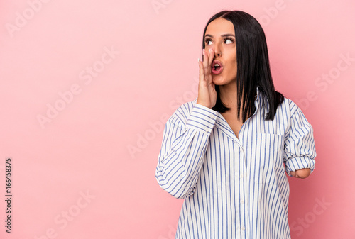 Young caucasian woman with one arm isolated on pink background is saying a secret hot braking news and looking aside © Asier