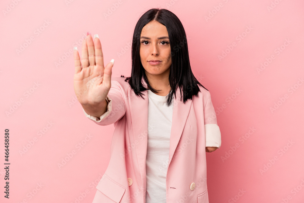 Young caucasian woman with one arm isolated on pink background standing with outstretched hand showing stop sign, preventing you. Young caucasian woman with one arm isolated on pink background standing with outstretched hand showing stop sign, preventing you.