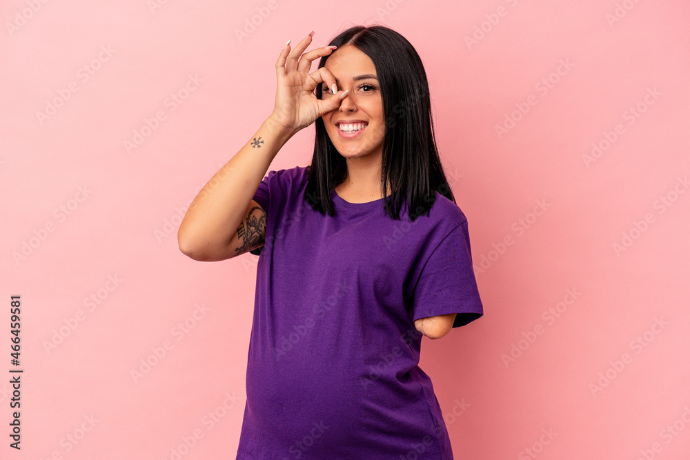 Young pregnant woman with one arm isolated on pink background excited keeping ok gesture on eye. Young pregnant woman with one arm isolated on pink background excited keeping ok gesture on eye.