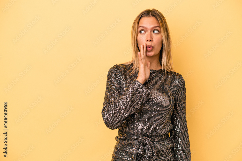 Young caucasian woman celebrating new year isolated on yellow background is saying a secret hot braking news and looking aside Young caucasian woman celebrating new year isolated on yellow background is saying a secret hot braking news and looking aside