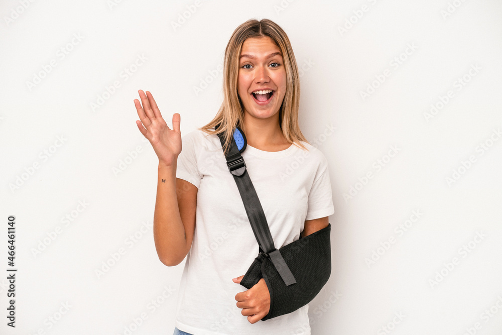 Young caucasian woman with broken hand isolated on white background receiving a pleasant surprise, excited and raising hands. Young caucasian woman with broken hand isolated on white background receiving a pleasant surprise, excited and raising hands.