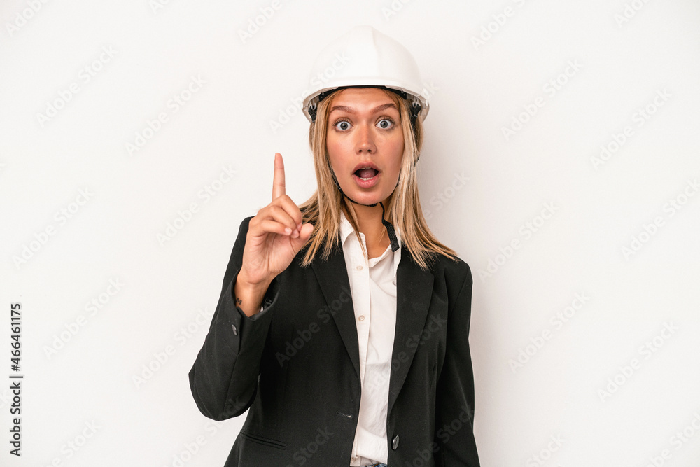 Young caucasian architect woman wearing a helmet isolated on white background having an idea, inspiration concept.