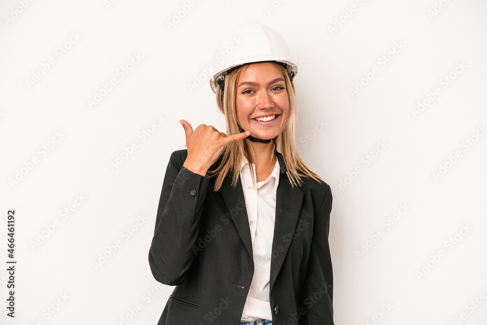 Young caucasian architect woman wearing a helmet isolated on white background showing a mobile phone call gesture with fingers. Young caucasian architect woman wearing a helmet isolated on white background showing a mobile phone call gesture with fingers.