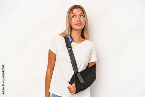 Young caucasian woman with broken hand isolated on white background dreaming of achieving goals and purposes
