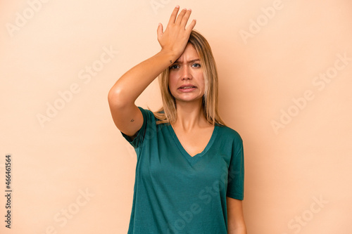 Young caucasian woman isolated on beige background forgetting something, slapping forehead with palm and closing eyes.