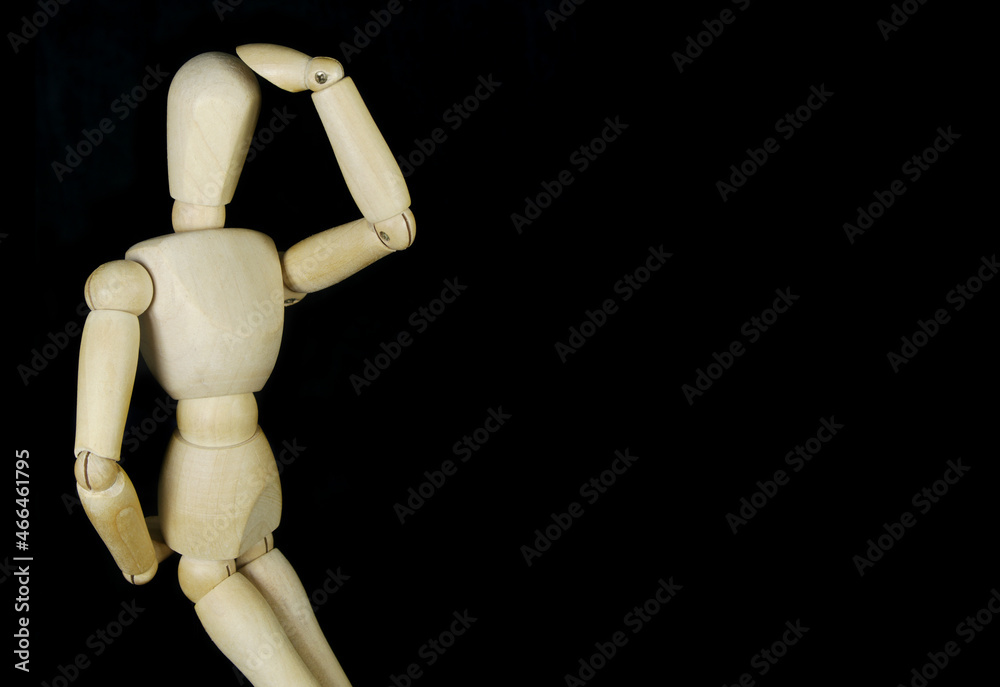 Wooden mannequin thinking about problem isolated on black background, copy space for text Wooden mannequin thinking about problem isolated on black background, copy space for text