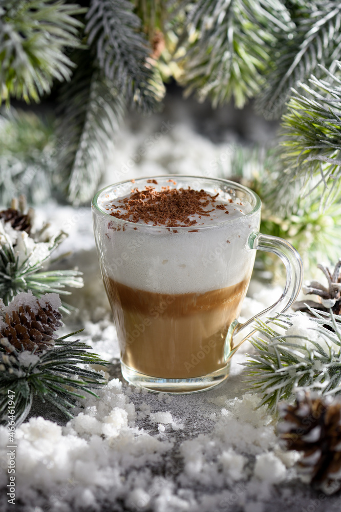 Christmas latte macchiato. A great hot coffee drink with chocolate shavings, among the snow-covered pine branches and snow. Christmas latte macchiato. A great hot coffee drink with chocolate shavings, among the snow-covered pine branches and snow.