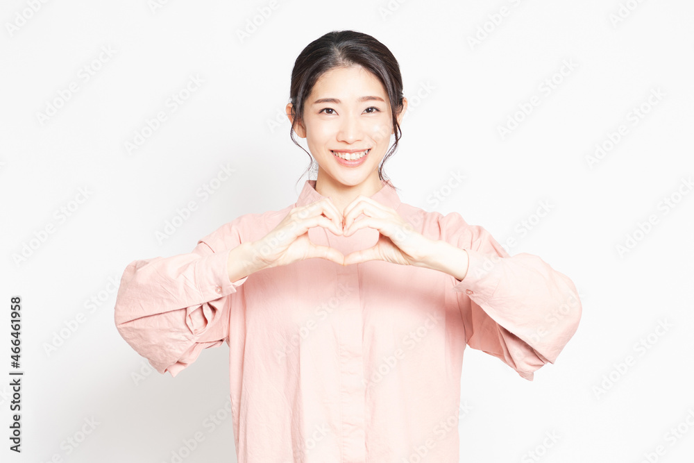 手でハートの形を作って愛情を表現する女性