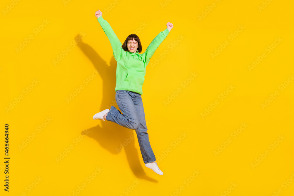 Full length body size view of attractive lucky cheerful girl jumping rejoicing isolated over bright yellow color background