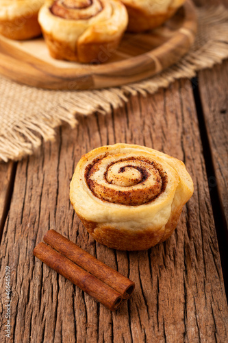 Cinnamon rolls on wooden background.