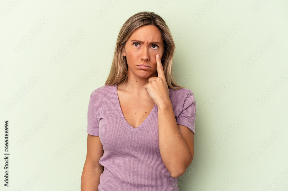 Young caucasian woman isolated on green background crying, unhappy with something, agony and confusion concept. Young caucasian woman isolated on green background crying, unhappy with something, agony and confusion concept.