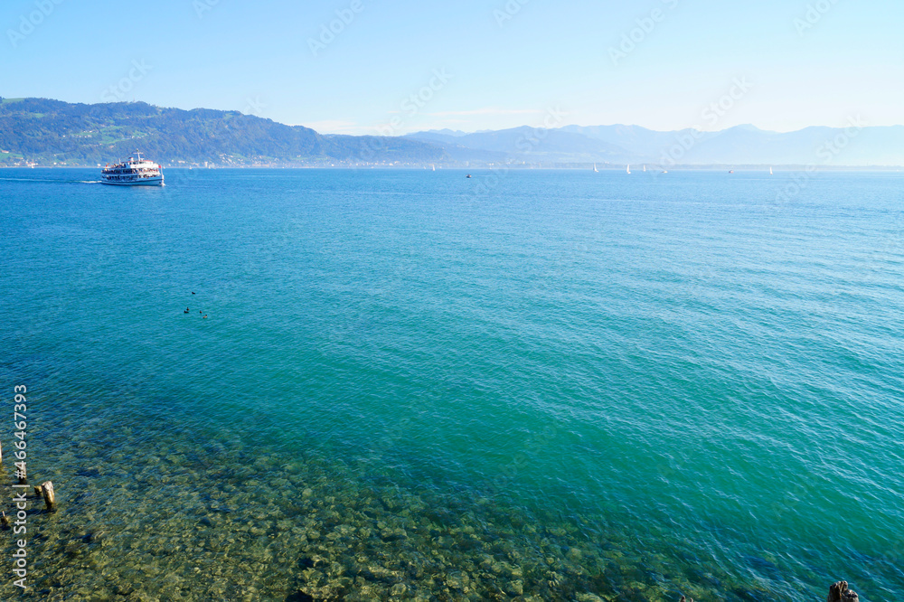 gorgeous turquoise water of lake Constance (Bodensee) with the Alps in the background seen from the shores of Lindau island on a sunny spring day in Germany gorgeous turquoise water of lake Constance (Bodensee) with the Alps in the background seen from the shores of Lindau island on a sunny spring day in Germany