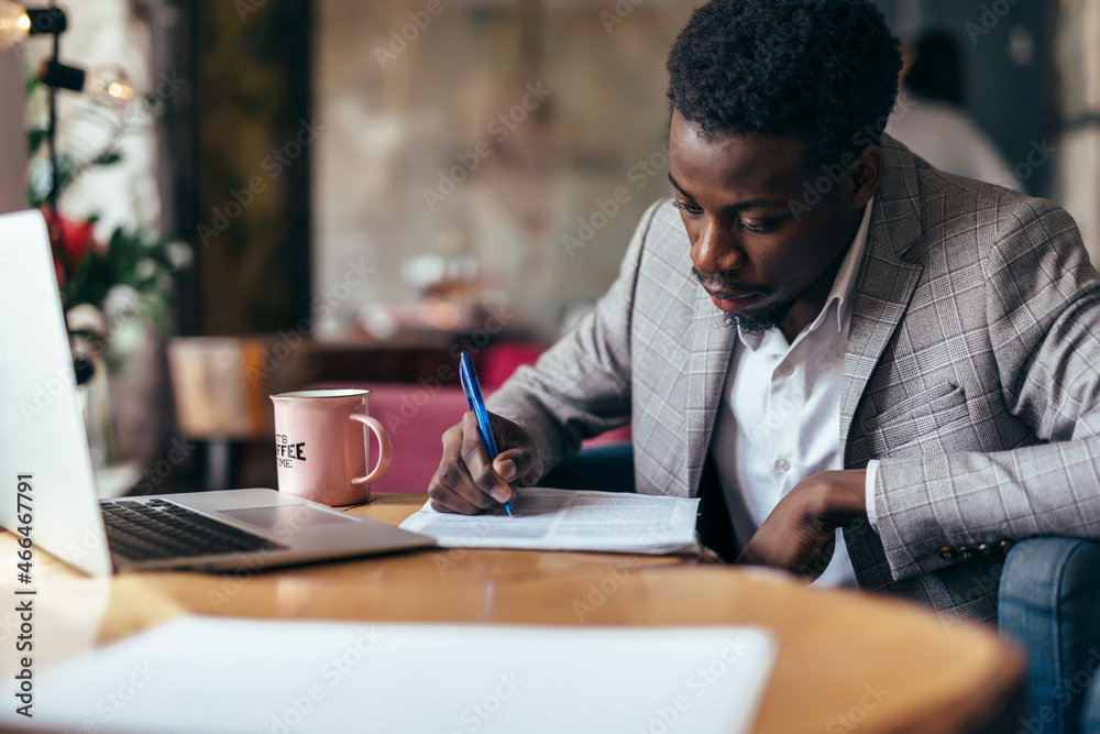 Black man working with documents, writing on paper