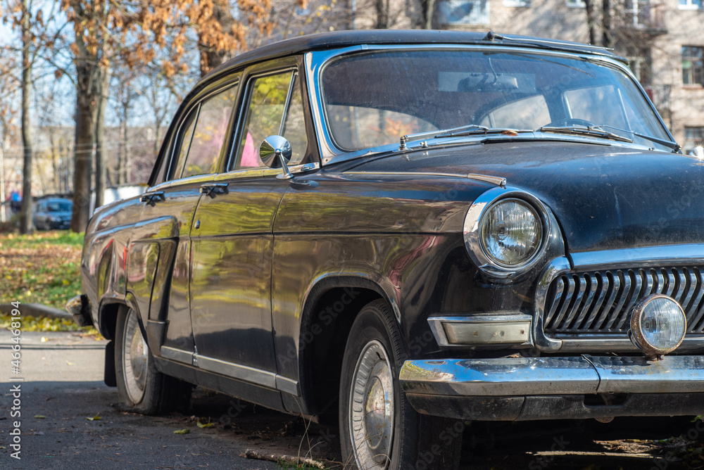 Parked retro car close-up, right side view, blurred background