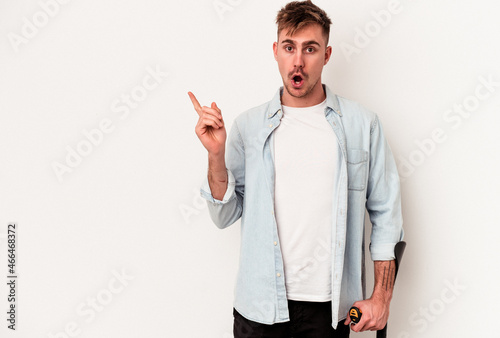 Young caucasian man holding crutch isolated on white background pointing to the side photo