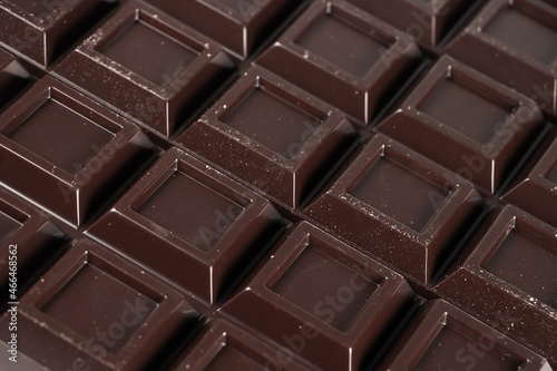 Close up a chocolate bar background. Chocolate bar cubes macro