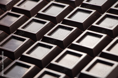 Close up a chocolate bar background. Chocolate bar cubes macro