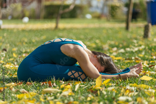 relax at the park, young woman in blue clothes, balance, fitness, stretching and relaxation	