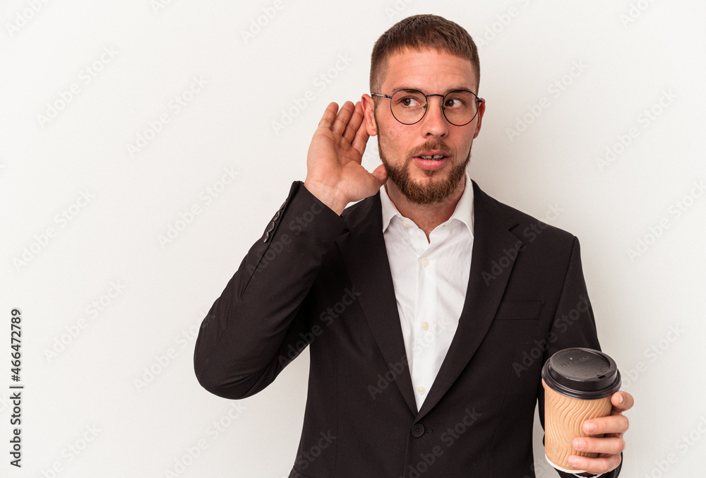 Young business caucasian man holding take away coffee isolated on white background trying to listening a gossip. Young business caucasian man holding take away coffee isolated on white background trying to listening a gossip.