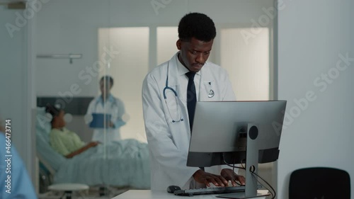 Wallpaper Mural African american medic working with computer and keyboard to find treatment and information. Healthcare specialist using monitor to give prescription medicine to ill patient. Medical worker Torontodigital.ca