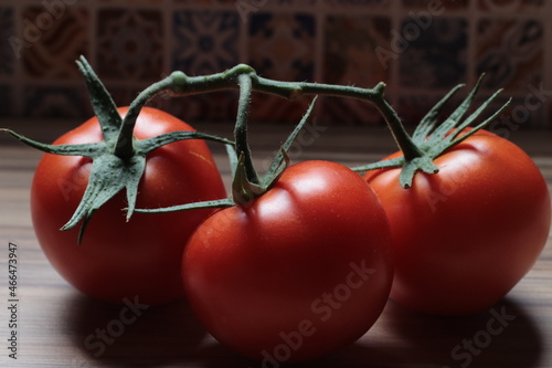 Tomates vermelhos com cabo verde e cozinha, madeira, ladrilho colorido photo