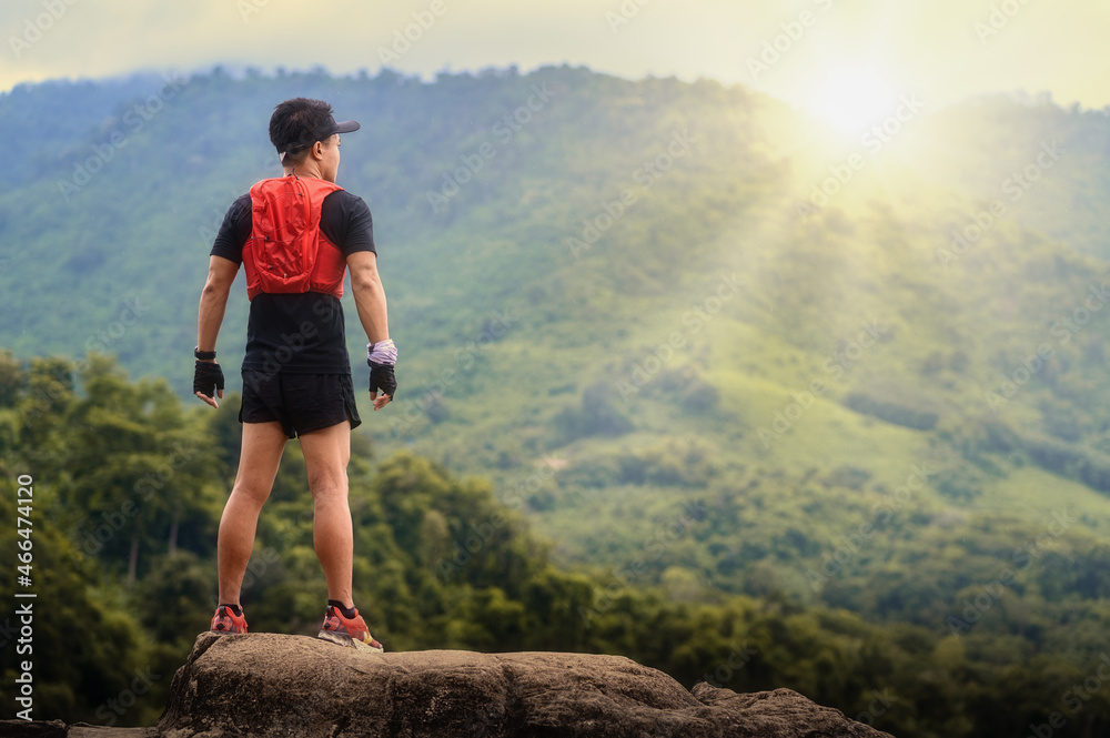 Man preparing for workout and trail running outdoors. Amazing mountain view on background. Adventure sports concept.