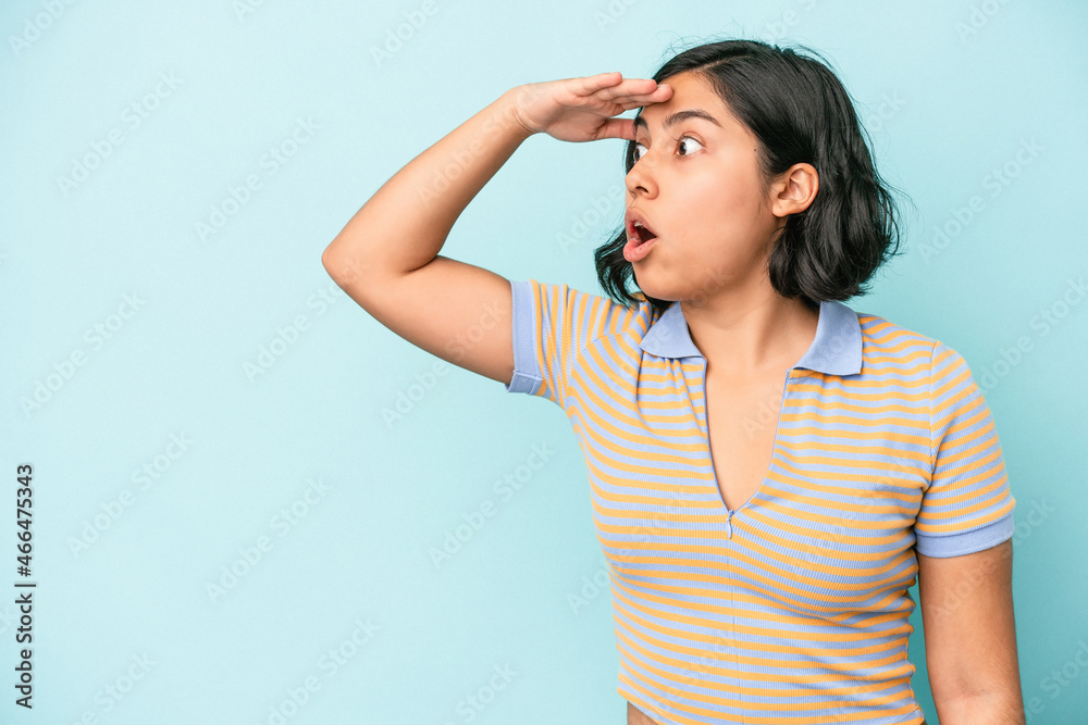 Young latin woman isolated on blue background looking far away keeping hand on forehead. Young latin woman isolated on blue background looking far away keeping hand on forehead.
