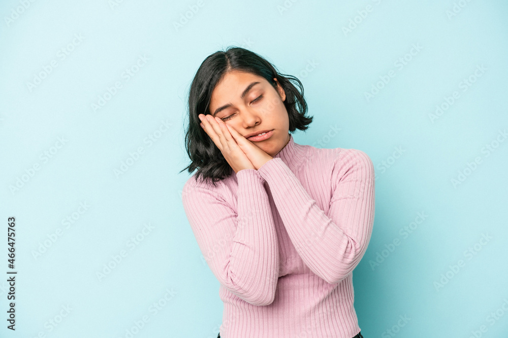 Young latin woman isolated on blue background yawning showing a tired gesture covering mouth with hand. Young latin woman isolated on blue background yawning showing a tired gesture covering mouth with hand.