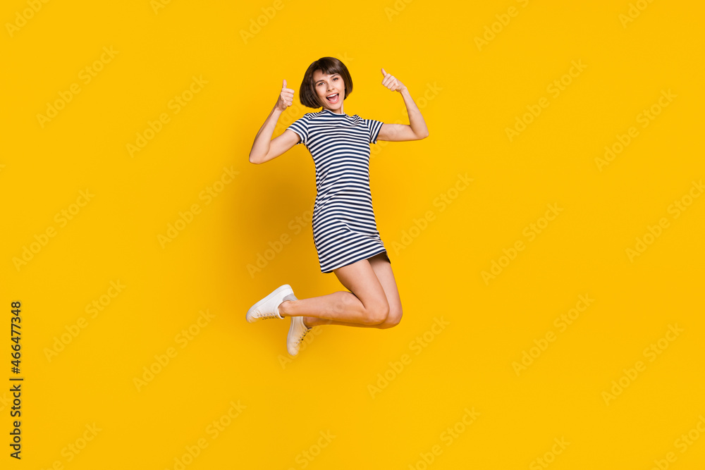 Full body photo of cool young lady jump thumb up wear blue dress sneakers isolated on yellow background